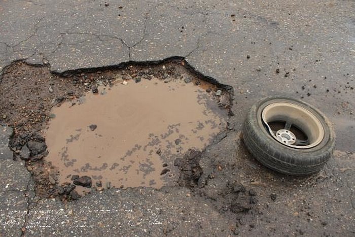 Колесо попало в яму на дороге. Ямы на дорогах. Глубокая яма на дороге. Ямы на дороге и автомобиль. Колесо в яме.